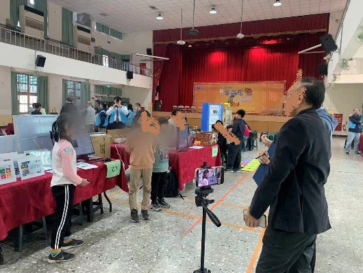 學生在成果場合中展示並說明科技創作